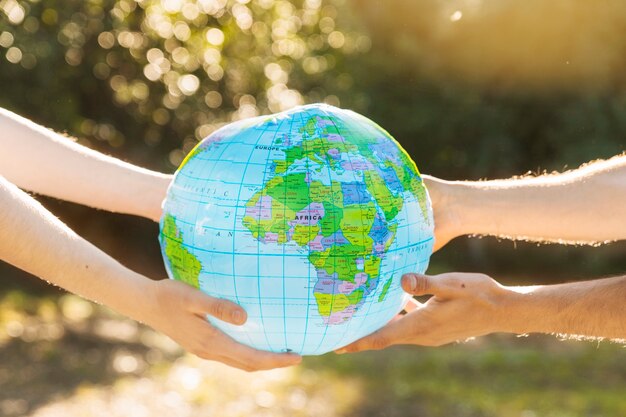 Hands holding planet model in sunlight