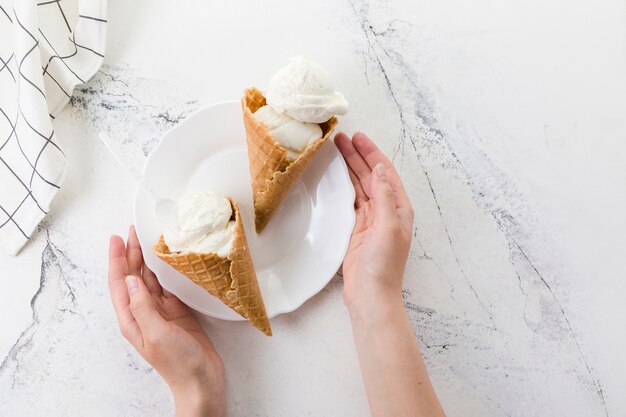 Hands holding plate with delicious dessert