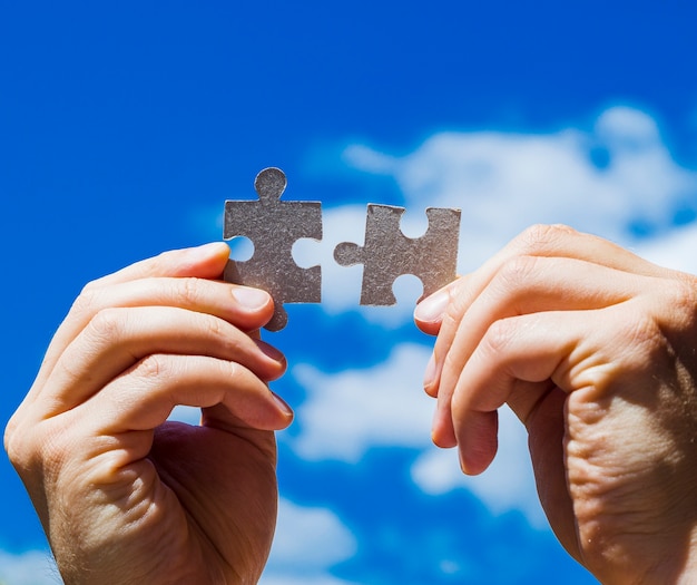 Hands holding puzzle pieces close-up