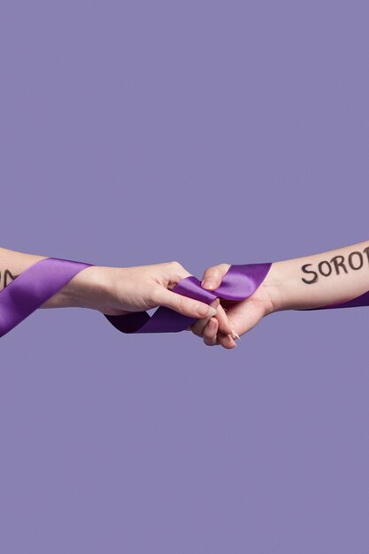 Hands holding a ribbon while covered in empowering words