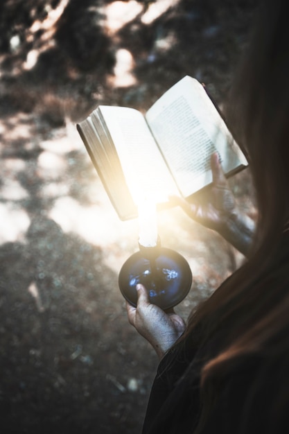 Foto gratuita mani che tengono il volume e la candela rituali