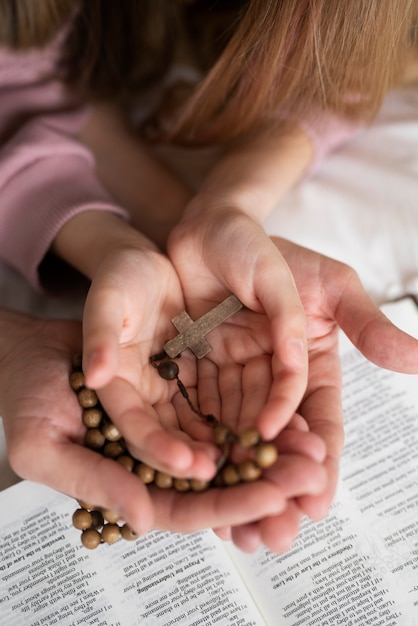 Free photo hands holding rosaries high angle