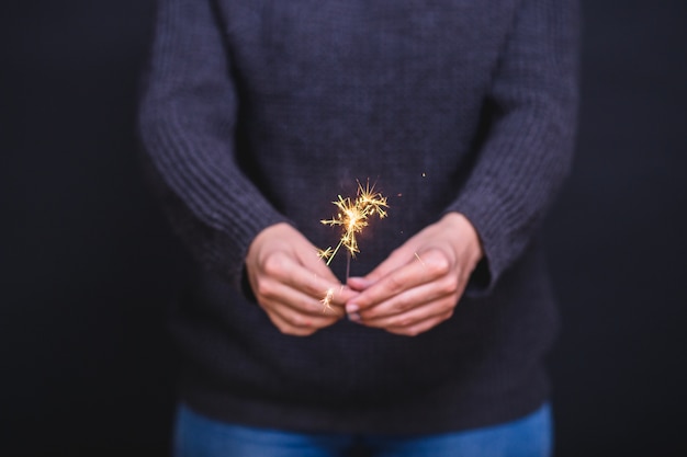 Free photo hands holding sparkler