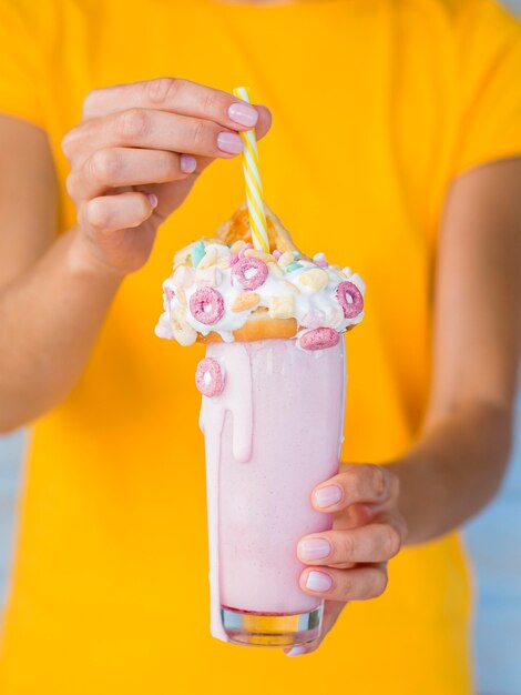 Руки держат вкусный розовый молочный коктейль
