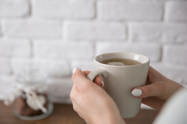 手、茶色のマグカップ