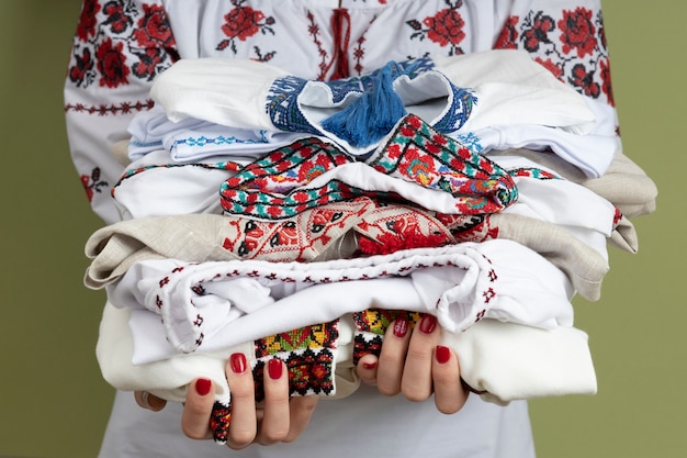 Free photo hands holding traditional embroidered shirts