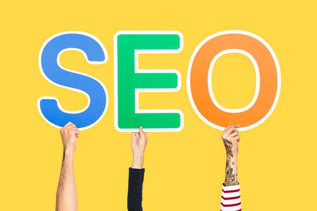 Hands holding up colorful letters forming the abbreviation  SEO
