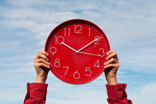 Hands holding wall clock still life