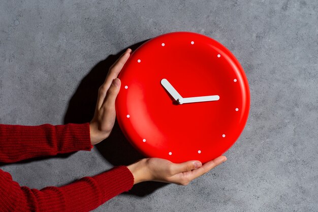 Hands holding wall clock still life