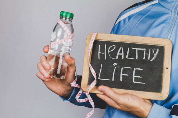 Hands holding a water bottle and a slate