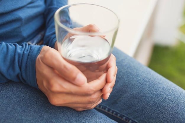 Hands holding a water glass