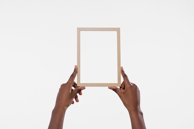 Hands holding wooden frame with white background