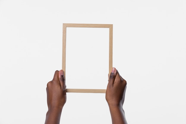 Free photo hands holding wooden frame