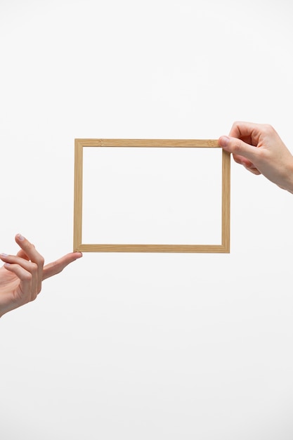 Free photo hands holding wooden frame