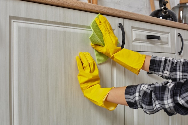 無料写真 緑の布で手袋をはめた手は、キッチン キャビネット - 家事と家事の概念を掃除しています。閉じる