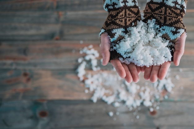 Hands in knitted gloves with snow 