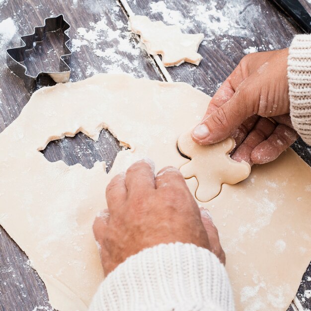 Hands making man shaped cookie from pastry