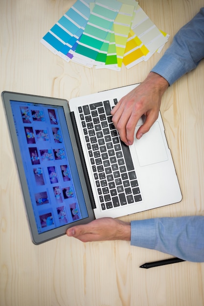 Hands of male graphic designer using laptop