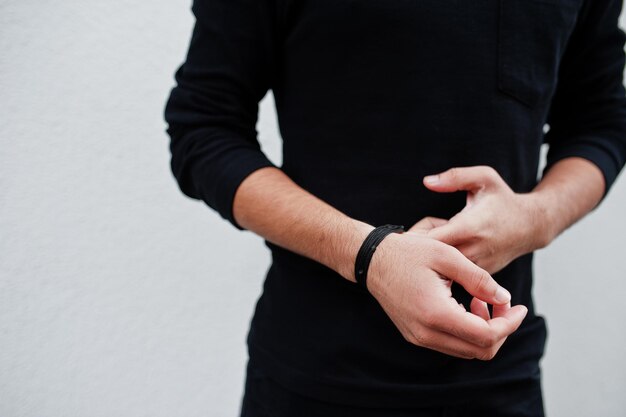 Hands of man in a fashionable black show bracelet beads