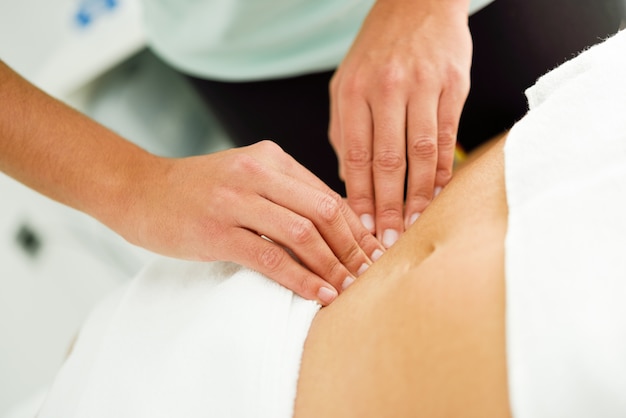 Hands massaging female abdomen.Therapist applying pressure on belly.