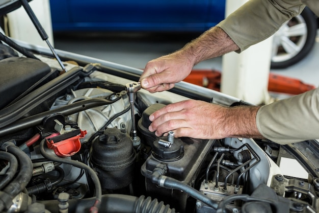 Hands of mechanic servicing a car