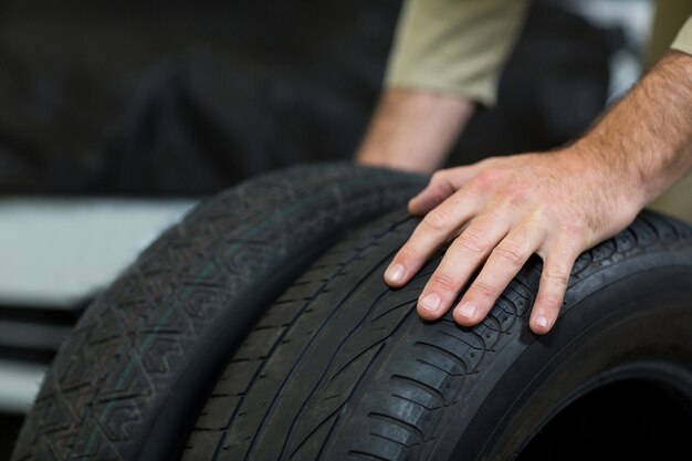 Hands of mechanic touching tyres