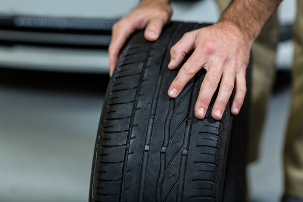 Hands of mechanic touching tyres