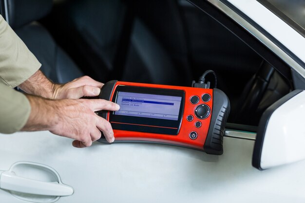 Hands of mechanic using a diagnostic tool