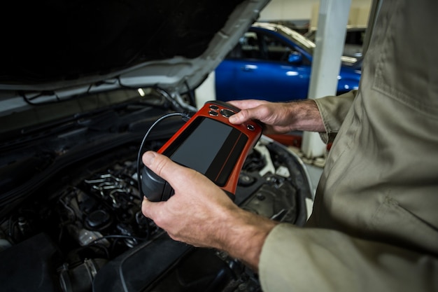 Hands of mechanic using a diagnostic tool