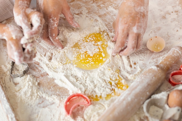 Hands mixing flour and eggs for dough
