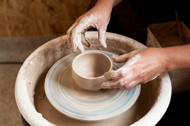 Free photo hands modeling in clay on a potter's wheel