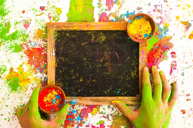 Hands near frame with colours in bowls between bright dry colors