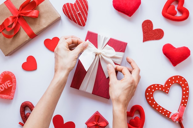 Hands near present between set of ornament hearts