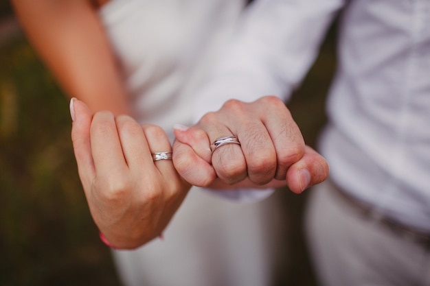 서로의 작은 손가락을 잡고 신혼의 손입니다. 당신의 손에 결혼 반지