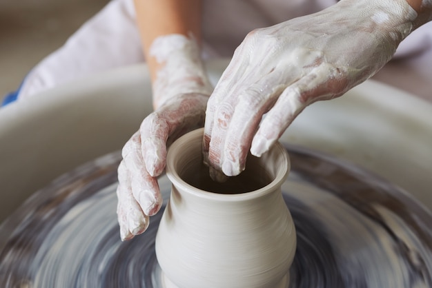 無料写真 投げホイールに粘土の花瓶を作る認識できない女性陶工の手