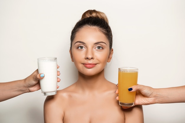 Hands offering juice or milk to young beautiful woman