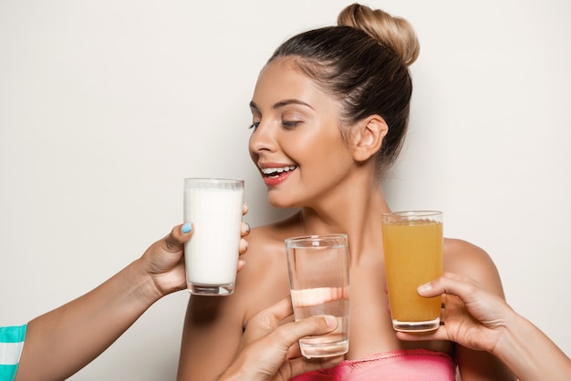 Foto gratuita mani che offrono acqua, succo o latte alla bella donna