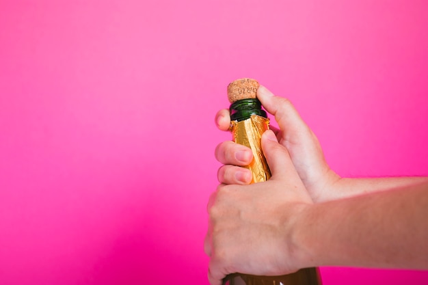 Руки открывают бутылку шампанского