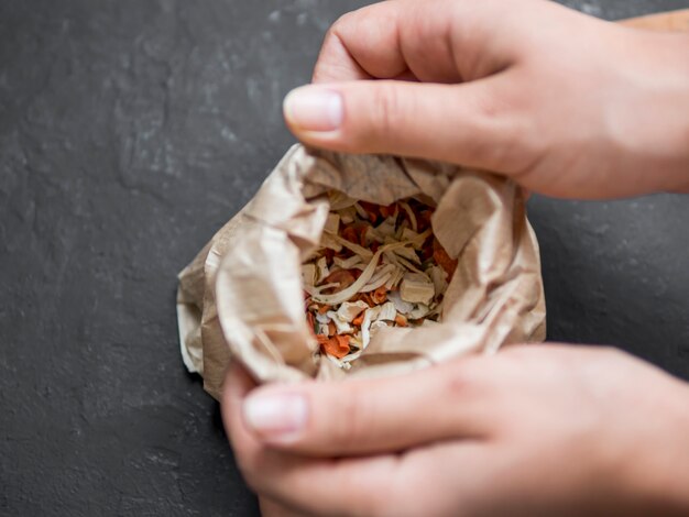 Hands opening paper bag full of spices