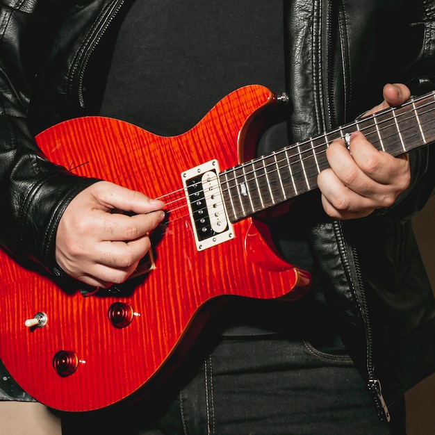 Hands playing beautiful red guitar