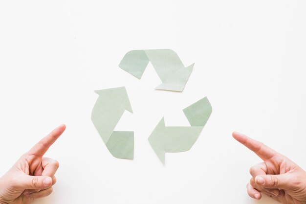 Hands pointing at recycle logo 