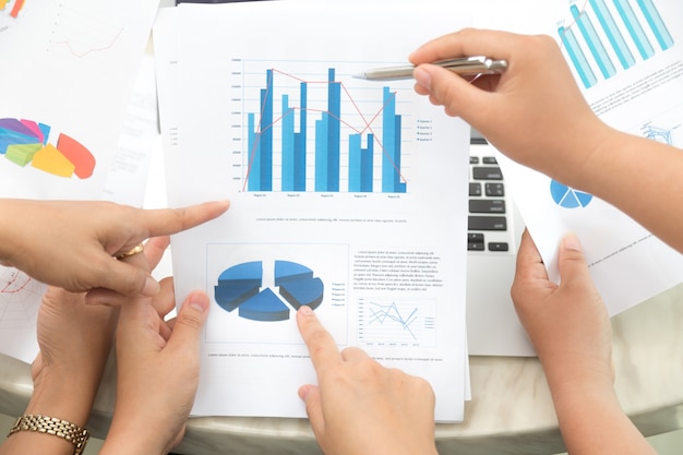 Hands pointing to a statistical document