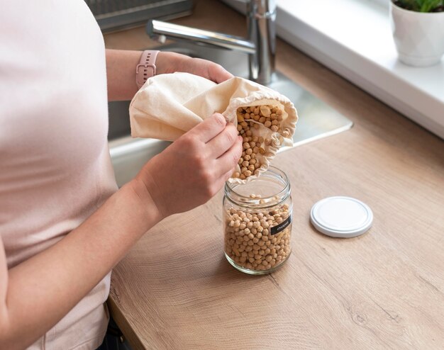 Hands pouring chickpeas from bag close up