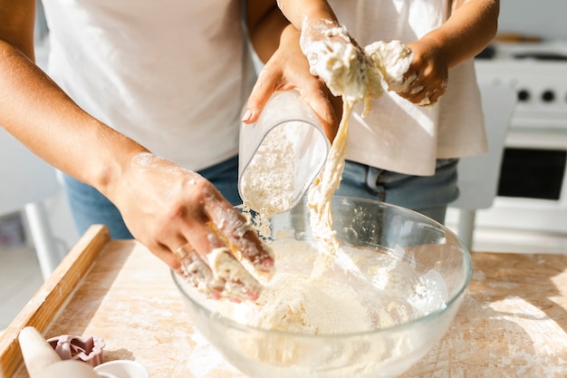 Free photo hands pouring flour in a bowl