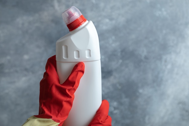 hands in protective gloves holding cleaning supply