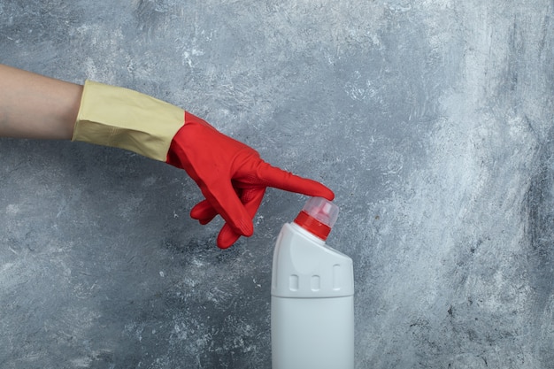 Hands in protective gloves touching tip of cleaning supply.