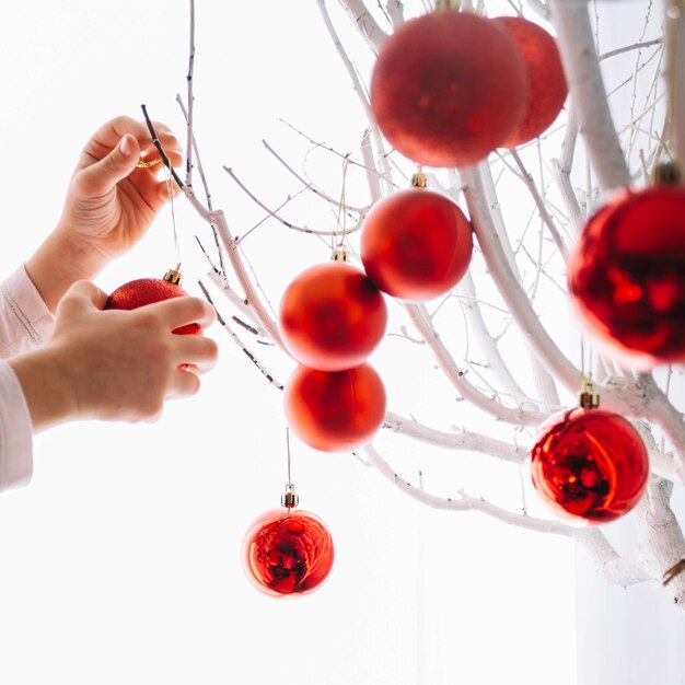 Hands putting christmas balls on tree