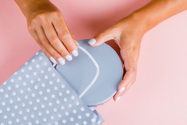 Hands putting gift box into paper bag