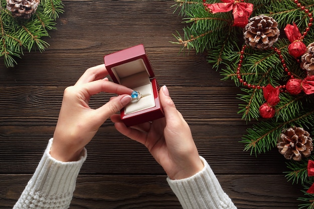 Free photo hands putting a ring in a red box