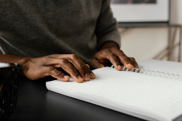 Hands reading braille notebook close up